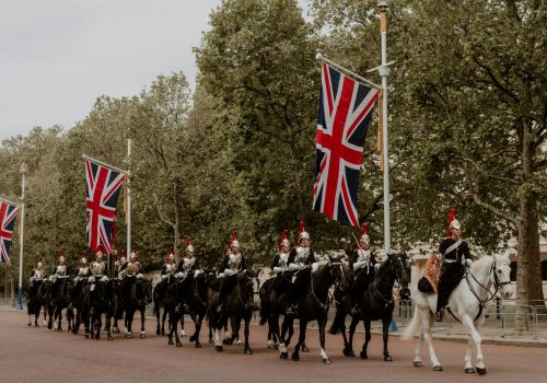 Ceremonial cavalry with Union Flags in a historical parade on The Mall, London.