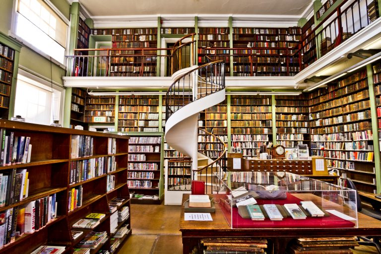 Explore a historic library in England with elegant spiral staircase and extensive bookshelves.