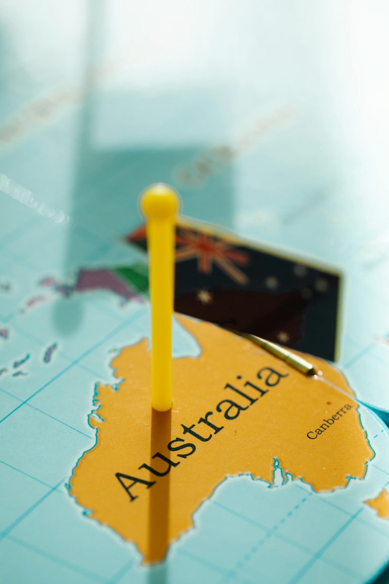 Close-up of Australia on a map with a yellow pin and flag, highlighting geography.